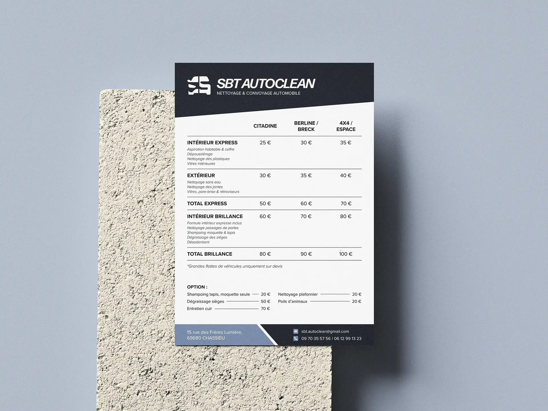 Flyer tarifaire SBT Autoclean posé sur un support texturé, avec logo, prestations de nettoyage automobile, tarifs et coordonnées.